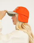 Person wearing a red cap and a white sweatshirt with red text on a light background