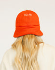 Person wearing a red cap and a white sweatshirt with red text on a light background
