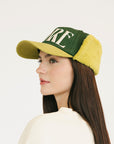 Person wearing a green and avocado cap with 'FORE' on a white background
