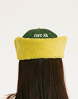 Person wearing a green and avocado cap with 'FORE' on a white background
