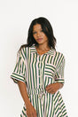 Woman wearing a green and white striped dress on a white background