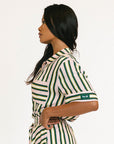 Woman wearing a green and white striped top and skirt on a white background