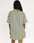 Woman wearing a green and white striped top and skirt on a white background
