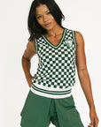 Woman wearing a green and white checkered sleeveless top and shorts on a white background