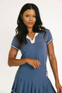Woman wearing a blue polo with white accents on a plain background