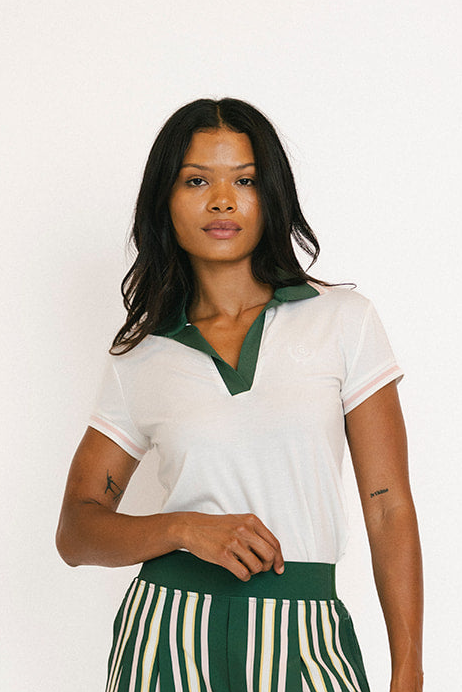 Woman wearing a white blouse with green trim and green striped pants against a white background