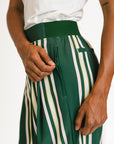 Person wearing green and white striped pants with a white top on a white background