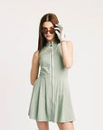 Woman wearing a light green sleeveless dress with a white background