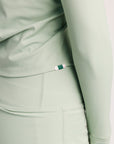 Close-up of a light green athletic outfit with a brand tag.