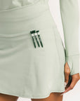 Light green skirt with a pocket containing three green items on a white background