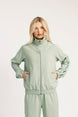 Woman wearing a light green tracksuit on a white background