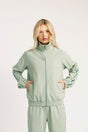 Woman wearing a light green tracksuit on a white background