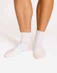 White and pink socks worn by a person on a white background