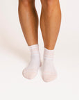 White and pink socks worn by a person on a white background