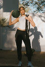 Woman holding a medicine ball and rope in an outdoor setting