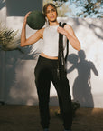 Woman holding a medicine ball and rope in an outdoor setting
