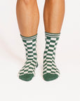 Green and white checkered socks worn by a person on a white background