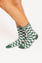 Green and white checkered socks worn by a person on a white background