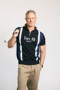 A man wearing a navy zip sweater with vertical white stripes and the text 'Fore All' on the chest, paired with beige pants.