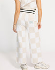 Person wearing a white and sand checkered Kennedy outfit with a plain background