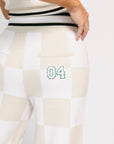 White and beige checkered pants with a green number 04 on a white background