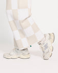 Person wearing a white and sand checkered Kennedy outfit with a plain background