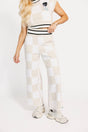 Person wearing a white and sand checkered Kennedy outfit with a plain background