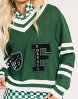 Green sweater with 'FOREALL' logo worn by a person on a white background