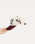 Cap with 'FORE' text held by a hand on a white background