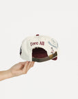 Cap with 'FORE' text held by a hand on a white background