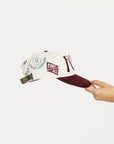 Cap with 'FORE' text held by a hand on a white background
