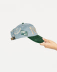 Cap with 'FORE' text held by a hand on a light gray background