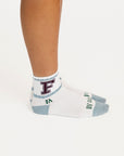 Person wearing socks with a visible brand logo on a white background