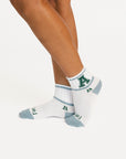 Person wearing socks with a visible brand logo on a white background