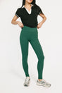 Person wearing a black top and green leggings on a white background
