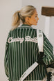 Person wearing a green and white striped cardigan with 'Chasing Balls' text.
