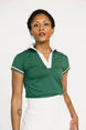 Woman wearing a green polo shirt with white trim on a white background