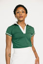 Woman wearing a green polo shirt with white trim on a white background