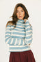 Woman wearing a blue and white striped sweater with 'FORE' text on a plain background