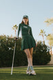 A female model wearing a long sleeve green and white ribbed baselayer top with raglan sleeves and colorblocking.