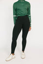 Person wearing a green long-sleeve top and black leggings on a white background
