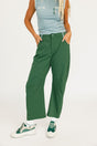 Person wearing green pants and a light blue top on a white background