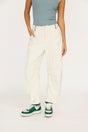 Person wearing white pants and green sneakers on a plain background