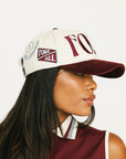Woman wearing a cap with 'FORE' branding on a white background