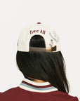 Woman wearing a cap with 'FORE' branding on a white background