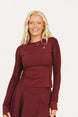 Woman wearing a burgundy outfit with a logo on a white background
