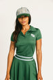 Woman wearing a green Brooklyn Polo and Brooklyn Skirt and a University Hat with visible branding on a white background