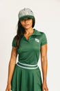 Woman wearing a green Brooklyn Polo and Brooklyn Skirt and a University Hat with visible branding on a white background