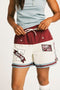 Person wearing the Fore All Fletcher short in merlot with branding on a plain background