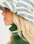 Person wearing the Fore All Austi Bucket Hat with a green sweater with a logo
